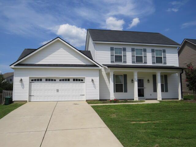 view of front of house with a porch, a garage, and a front lawn