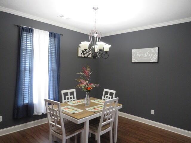 dining space featuring a chandelier, dark hardwood / wood-style floors, and ornamental molding