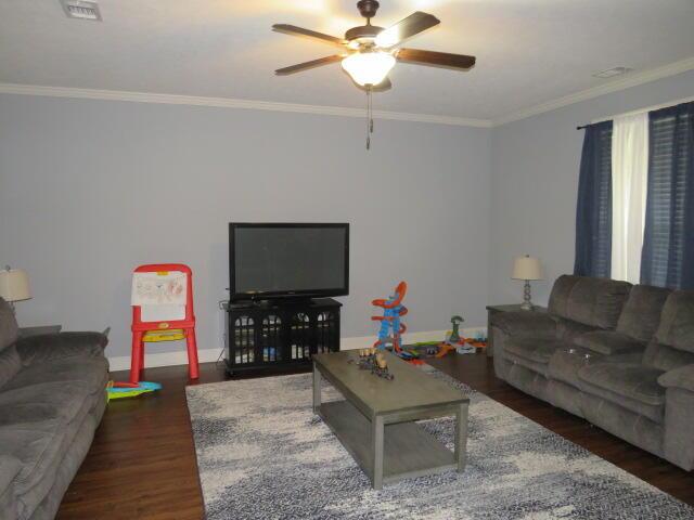 living room with ceiling fan, dark hardwood / wood-style flooring, and crown molding