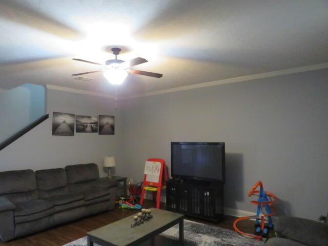 living room with crown molding, ceiling fan, and dark hardwood / wood-style floors