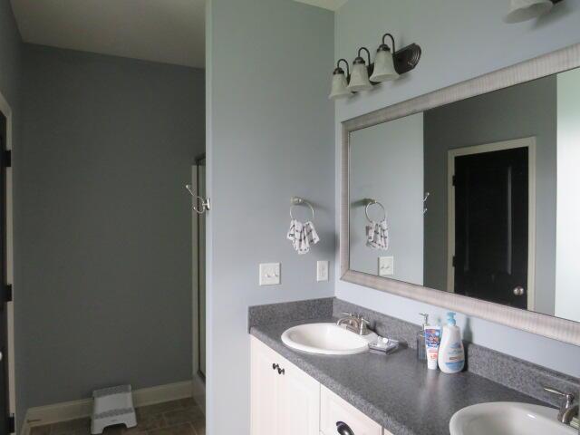 bathroom featuring vanity, tile patterned floors, and walk in shower