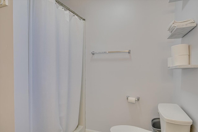 bathroom featuring a shower with shower curtain and toilet