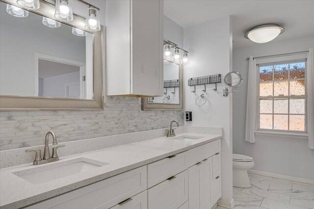 bathroom with toilet, marble finish floor, tasteful backsplash, and a sink