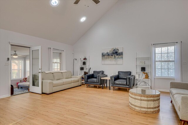 living room with high vaulted ceiling, wood finished floors, a ceiling fan, and baseboards