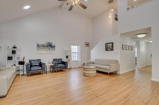 living room with baseboards, high vaulted ceiling, a ceiling fan, and light wood-style floors