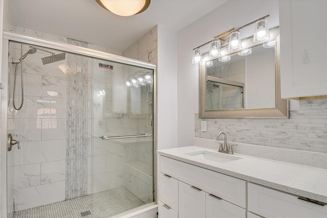 bathroom with tasteful backsplash, a stall shower, and vanity