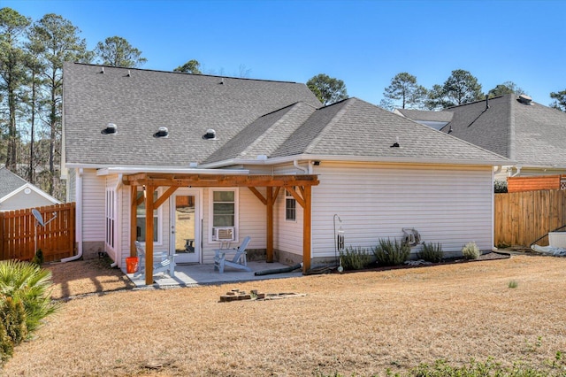 rear view of property with a patio area, a yard, fence, and roof with shingles