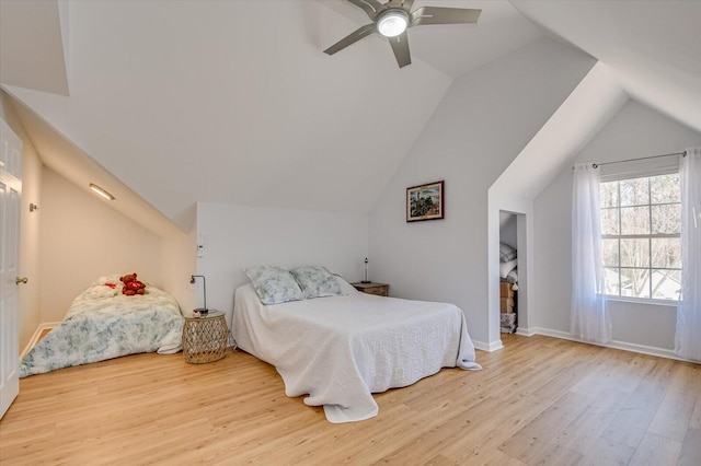 bedroom featuring lofted ceiling, wood finished floors, and baseboards