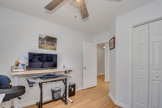 office area with light wood-style floors, baseboards, and a ceiling fan