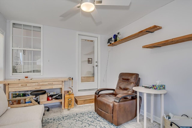 living area featuring marble finish floor and ceiling fan