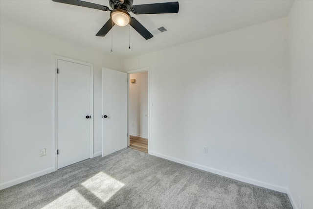 unfurnished bedroom with visible vents, a ceiling fan, baseboards, and carpet floors