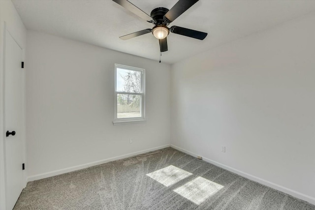 spare room with carpet flooring, baseboards, and ceiling fan