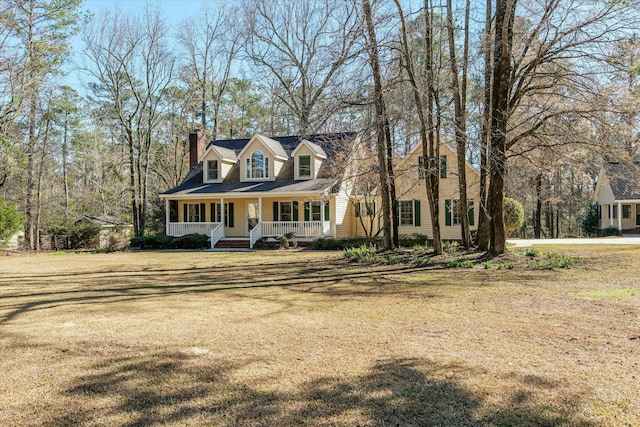 cape cod-style house with covered porch and a front lawn