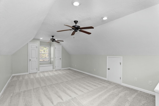 bonus room featuring light carpet, a textured ceiling, and lofted ceiling