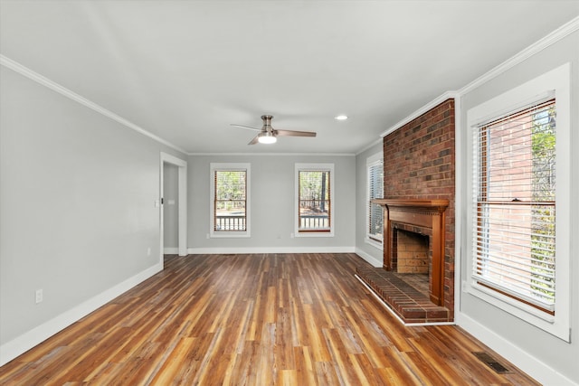 unfurnished living room featuring ornamental molding, hardwood / wood-style flooring, a brick fireplace, and ceiling fan