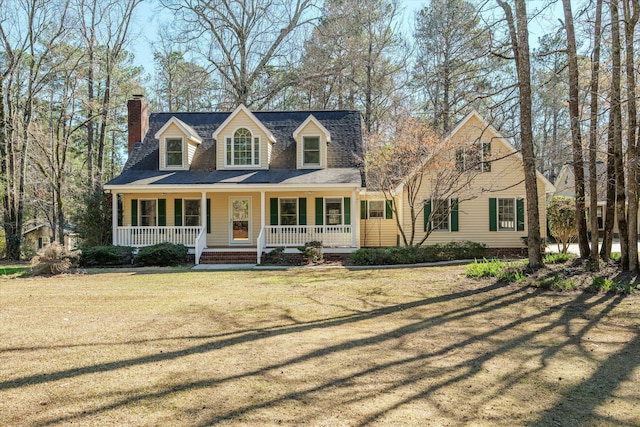 cape cod-style house featuring a front yard and a porch