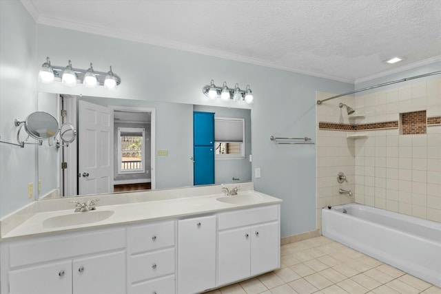 bathroom with vanity, a textured ceiling, tiled shower / bath, tile patterned flooring, and ornamental molding