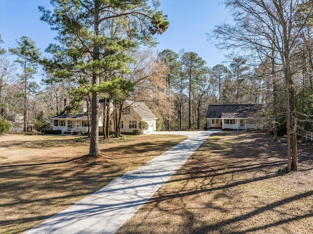 view of front of home with covered porch, a front yard, and a garage