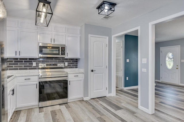 522 Gray Dr, Martinez, GA 30907 - kitchen featuring appliances with stainless steel finishes, decorative backsplash, light wood-style floors, white cabinets, and light stone counters