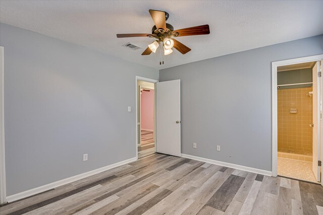 522 Gray Dr, Martinez, GA 30907 - unfurnished bedroom with light wood-type flooring, baseboards, ceiling fan, and connected bathroom