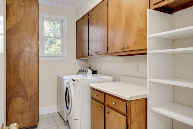 laundry area with cabinet space, ornamental molding, washing machine and dryer, light tile patterned flooring, and baseboards