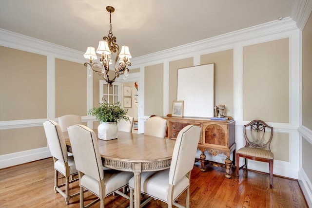 dining space with a chandelier, crown molding, light wood-style flooring, and baseboards