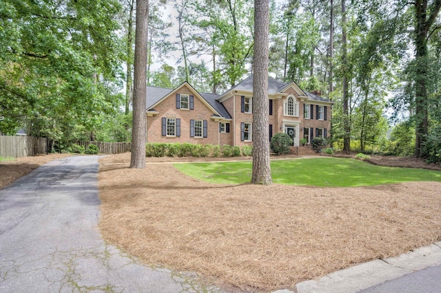 colonial house with brick siding and asphalt driveway