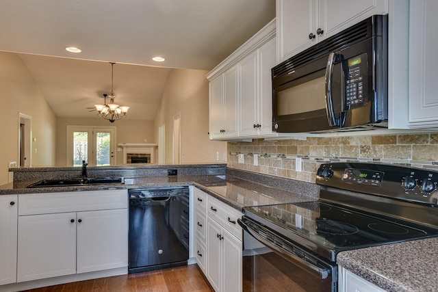 kitchen with sink, white cabinetry, lofted ceiling, and black appliances