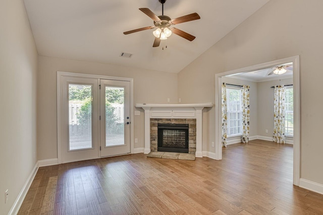 unfurnished living room featuring ceiling fan, a healthy amount of sunlight, a fireplace, and light hardwood / wood-style flooring