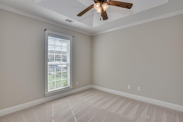 carpeted empty room featuring a raised ceiling, ceiling fan, and ornamental molding