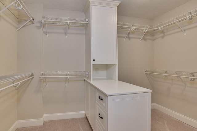 walk in closet featuring light colored carpet