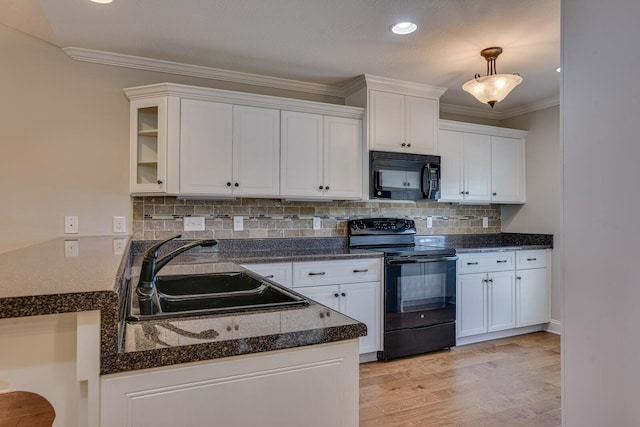 kitchen with sink, decorative light fixtures, white cabinetry, and black appliances