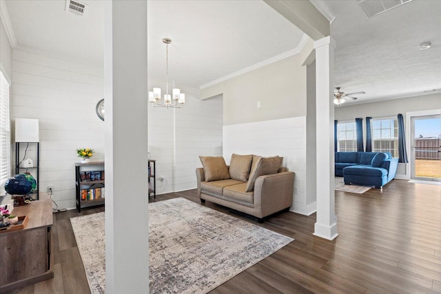 living room featuring visible vents, dark wood-type flooring, ornamental molding, and decorative columns