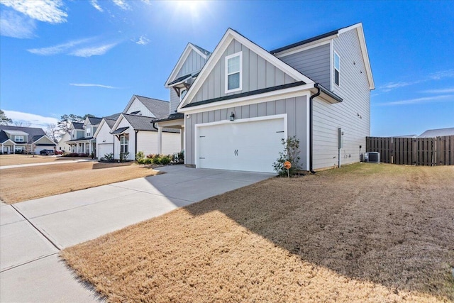 view of front of house featuring central air condition unit, driveway, fence, a residential view, and board and batten siding