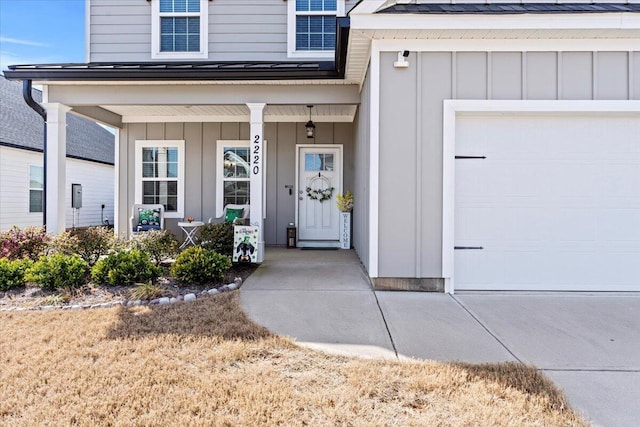 view of exterior entry featuring an attached garage, covered porch, and board and batten siding