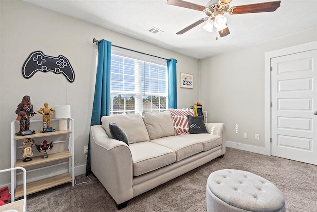 living room with carpet, baseboards, visible vents, and ceiling fan