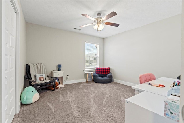 carpeted office with visible vents, baseboards, and ceiling fan