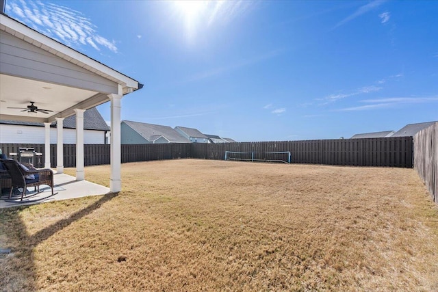 view of yard featuring a ceiling fan, a patio area, and a fenced backyard