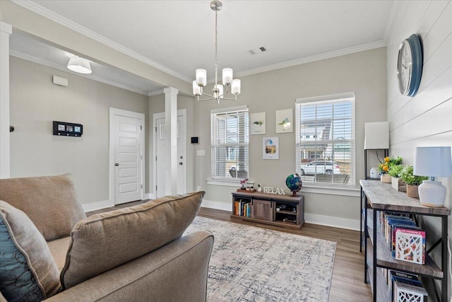 living area featuring ornamental molding, wood finished floors, visible vents, and baseboards