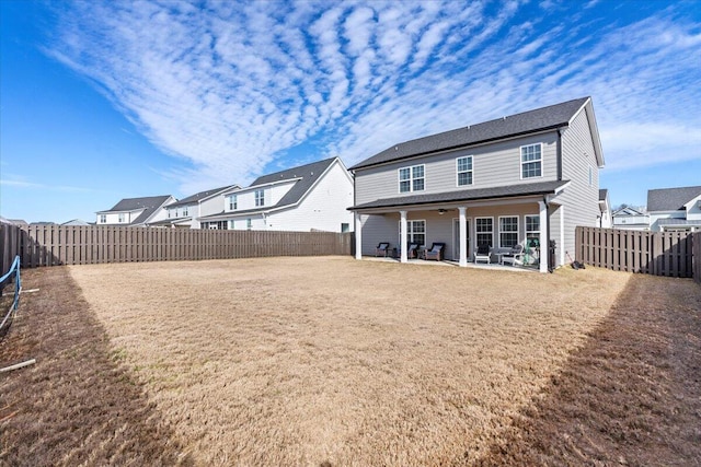 back of property featuring a patio, a lawn, and a fenced backyard