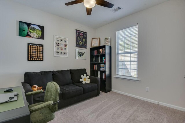 living area with visible vents, baseboards, carpet, and a ceiling fan