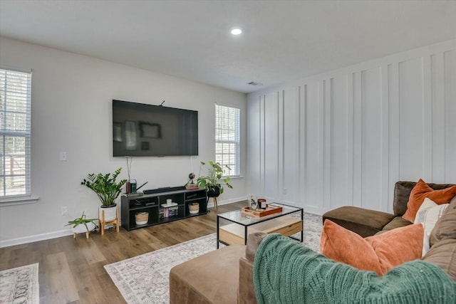 living area with recessed lighting, visible vents, baseboards, and wood finished floors