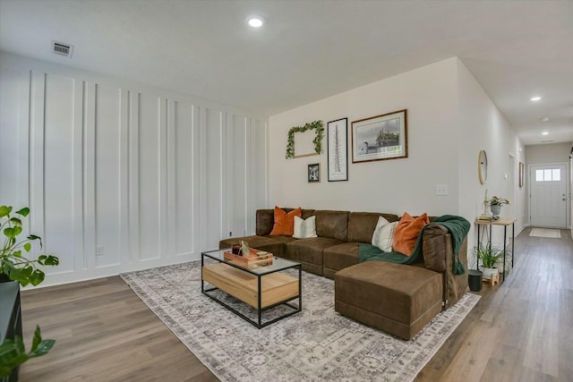 living room with recessed lighting, wood finished floors, and visible vents