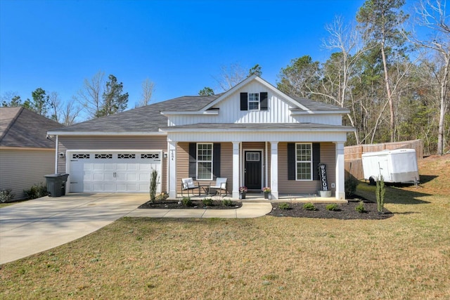 view of front of home featuring a porch, fence, concrete driveway, a front yard, and a garage