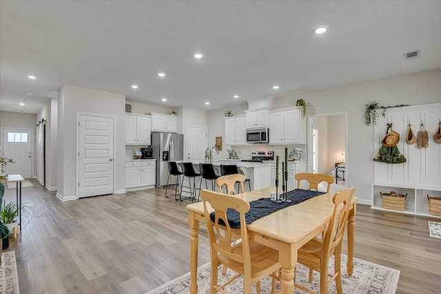 dining room featuring recessed lighting, light wood-type flooring, baseboards, and visible vents