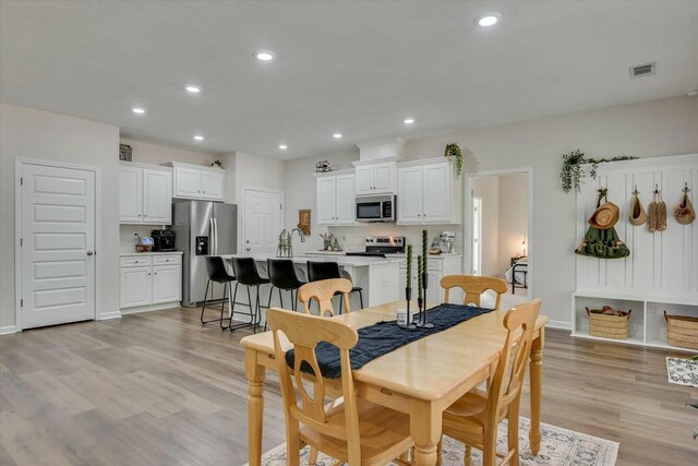 dining space with visible vents, recessed lighting, light wood-type flooring, and baseboards