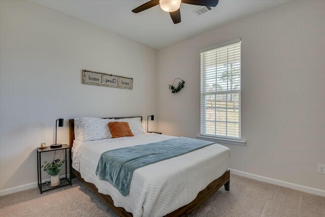 carpeted bedroom featuring visible vents, a ceiling fan, and baseboards