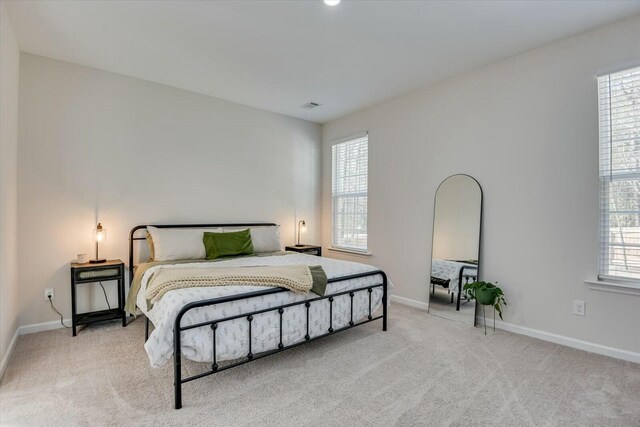 bedroom with visible vents, multiple windows, and carpet flooring