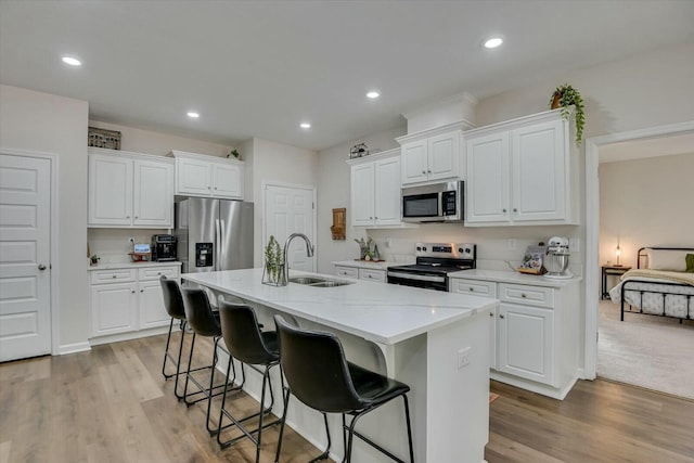 kitchen featuring a sink, an island with sink, recessed lighting, and stainless steel appliances