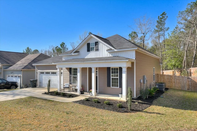 view of front of home with a front lawn, fence, covered porch, a garage, and driveway